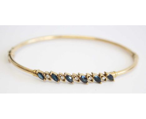 A modern 9ct hollow gold, sapphire and diamond set hinged bangle, arranged as six marquise cut and two claw-set sapphires, ea