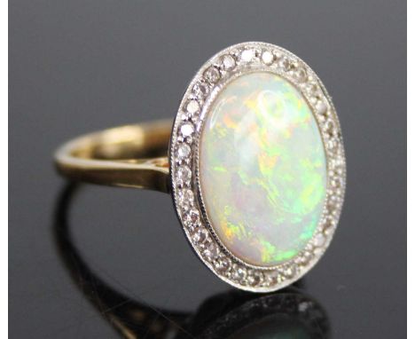 An 18ct yellow and white gold, opal doublet and diamond oval cluster ring, the opal doublet measuring approx 14 x 10 x 3.4mm,