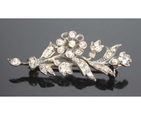 A white and yellow metal diamond floral spray brooch featuring 46 Old European cut diamonds in grain settings with a later ro