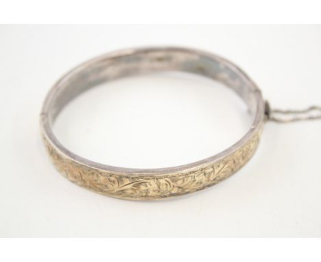 A silver and gold fronted vintage bangle with scrolling folitae design (15g) 
