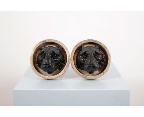A PAIR OF REGENCY STYLE LIONS HEAD CURTAIN TIE-BACKSthe gilt wooden circular bosses with reeded stems and wall fittings to th