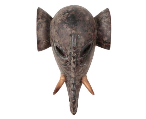 TWO AFRICAN WOODEN TRIBAL MASKSone of an elephant with curled trunk and tusks, 34cm high x 65cm wide x 30cm deep approx., the