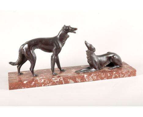 AN ART DECO BRONZE OF TWO BORZOI DOGSfacing each other, with one standing and the other reclining, unsigned, on oblong brown 