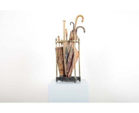 A BRASS SIX-COMPARTMENT STICK STAND19th century, with finials to each corner, containing mixed parasols and umbrellas, 62cm h