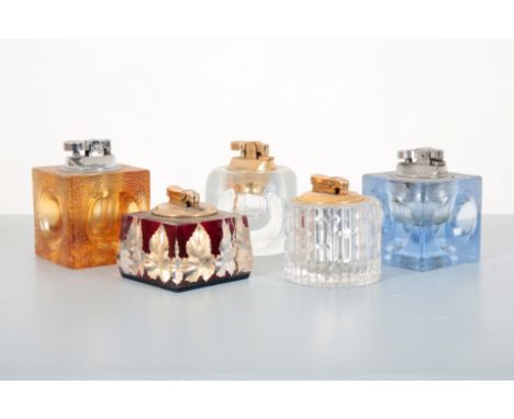 A COLLECTION OF GLASS TABLE LIGHTERSthree unsigned, of 1970s textured glass with round recesses and removable lighter tops, o