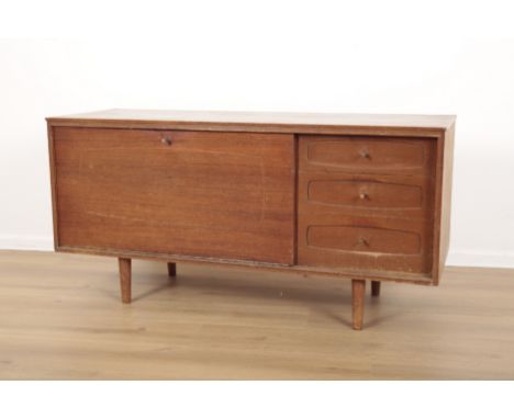 WHITE & NEWTON: A MID-CENTURY TEAK SIDEBOARDthe fall front enclosing single shelf, flanked by three drawers, on turned legs, 