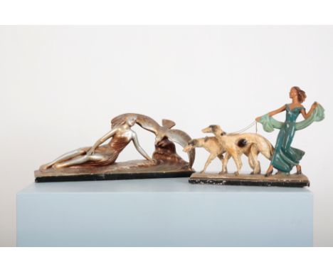 A LARGE ART DECO PLASTER SCULPTURE OF A LADY WALKING TWO BORZOIdressed in turquoise; together with a metallic finish chalkwar