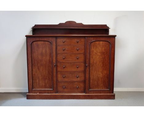 A WILLIAM IV MAHOGANY LOW WARDROBE with shaped shelf to the back, fitted with a central bank of six drawers, flanked by arche