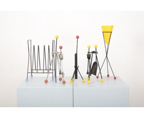 AN 'ATOMIC' MAGAZINE RACK AFTER ROGER FERAUD mid-century modern, of black enamelled metal and blue plastic finial feet, 41cm 