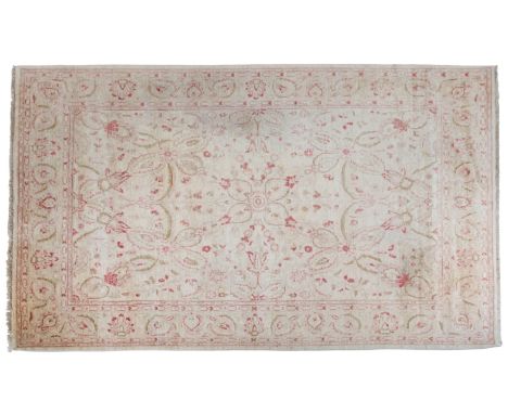 AN INDIAN CARPET OF TABRIZ STYLEwoven in pale green and red with classical Persian quatrefoil design on a cream ground, withi