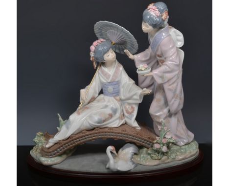 Lladro group of two Japanese girls on a garden bridge, with a stand, width 36cm.