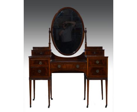 Mahogany dressing table, oval bevelled mirror back, with two raised trinket drawers and five drawers surrounding the kneehole