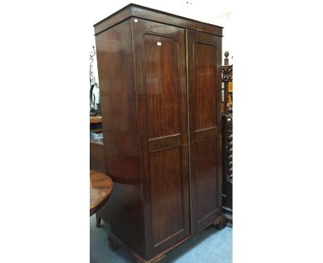 An early Victorian mahogany panel fronted two-door wardrobe raised on ogee bracket supports, 110cm by 58cm by 210cm 