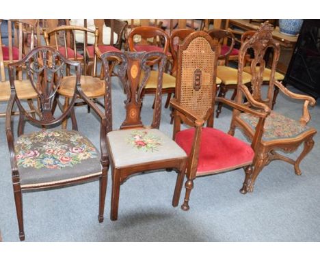 An early 20th century Flemish heavily carved walnut armchair, together with another armchair with canework back panel, a Geor