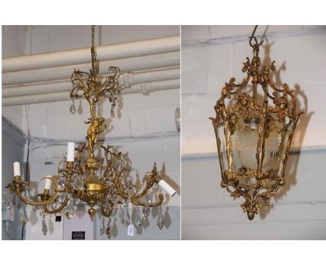 A gilt metal six light lustre chandelier, the scrolling arms issuing from a classical nude holding aloft further scrolls susp