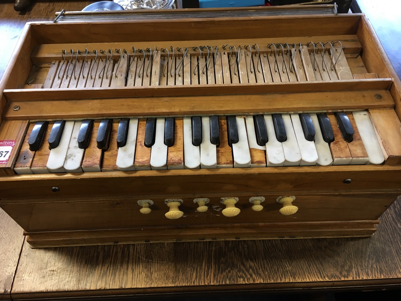 A walnut cased harmonium with bellows, having stops below keyboard