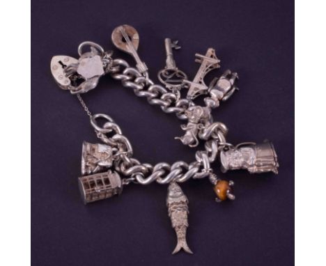 A curb style heavy gauge silver charm bracelet, padlock safety chain fitted, maker R&amp;S, circa 1961, 112g, assorted charms