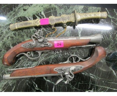 A pair of reproduction Flintlock pistols and a reproduction Eastern style dagger in a brass scabbard 