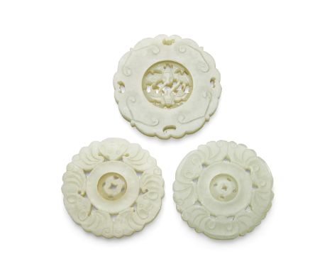 Three jade pendantsEach finished on both sides and undercut with a movable circular roundel: two carved as three bats surroun