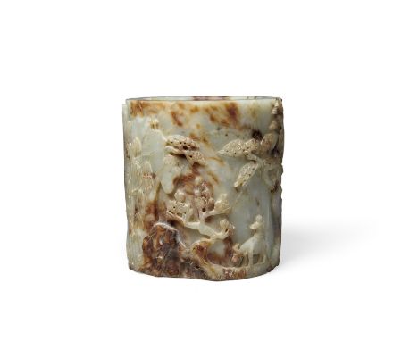 A GREEN AND BROWN JADE BRUSH POTIts thick walls carved all around with a landscape setting for deer climbing up a rocky incli