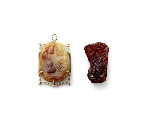 A mounted carved jade pendant and a small amber carvingThe first a jade of oval section and one side carved in relief with a 