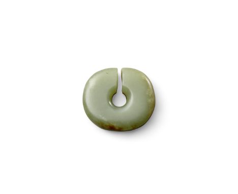 An archaistic jade slit discIn the style of a Neolithic Majiabang culture disc, of light green jade color, the thick, lustrou