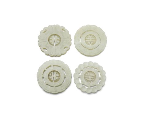 Four circular jade pendantsEach undercut with a movable shou medallion at the center: the first with a pearl border band join