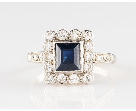 A mid-20th Century Art Deco style white metal sapphire and diamond ring, set with a central rectangular cut sapphire, measuri