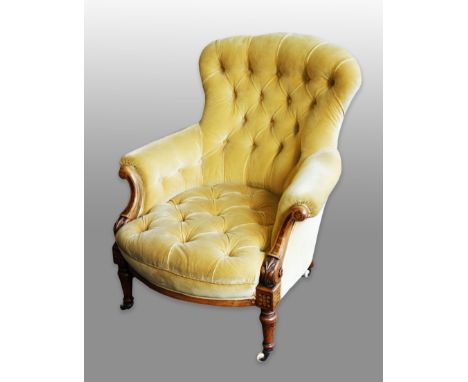 A Victorian walnut framed button backed arm chair with inlaid decoration on turned supports.