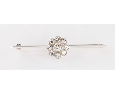 A white metal diamond flower head design bar brooch, rub over set with a central round brilliant cut diamond, approx. 0.20ct,