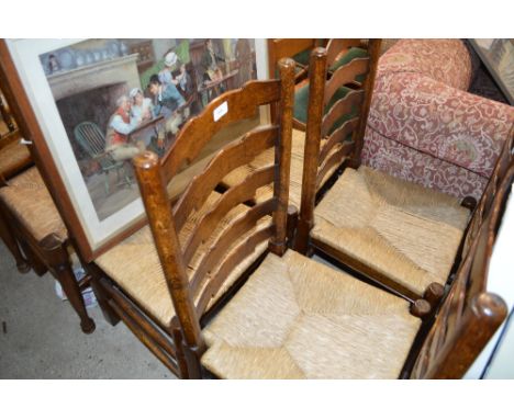 A set of six oak and rush seated ladder back dining chairs