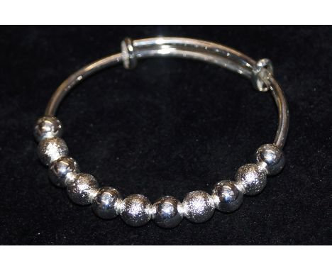 White metal extendable fashion bangle set with 11 frosted and clear "beads"