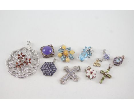 A collection of silver stone set pendants including ruby, opal and tanzanite 