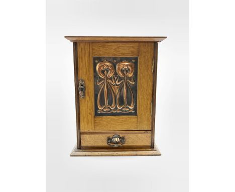 Early 20th Century oak smokers cabinet of Art Nouveau design with lifting top, fitted interior and single door with copper in