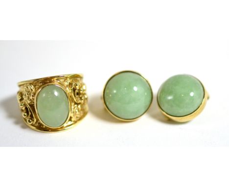 A 9 carat gold jade ring, an oval cabochon jade in a rubbed over setting, to a tapering shank with floral detail, finger size