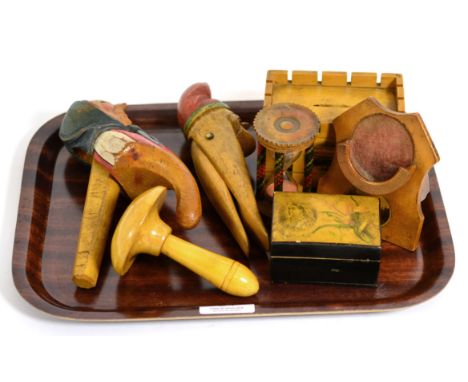 A tartan ware egg timer, Mauchline ware watch holder money box and darning mushroom; two figural wood nutcrackers and a Victo