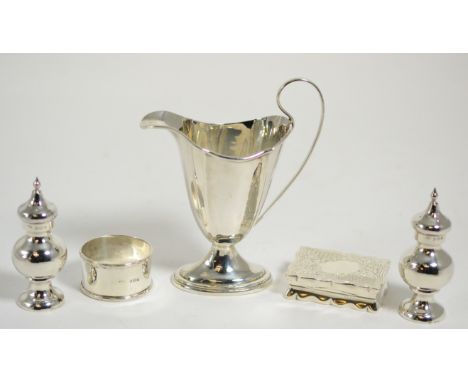 A pair of silver pepperettes, silver helmet cream jug, silver Victorian snuff box and a silver napkin ring 