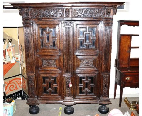 An early 18th Century North German oak "Zeeuwse Kast" or cupboard, enclosed by moulded panel doors beneath profusely carved f