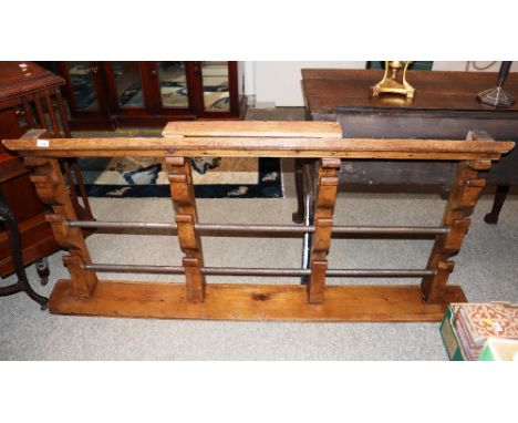 A 19th Century pine spit rack, with four arched supports and shelf base, complete with two iron poles, 164cm wide, 80cm high