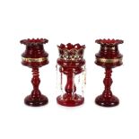 A pair of Victorian ruby glass lustre vases, decorated with a band of enamelled flowers raised on
