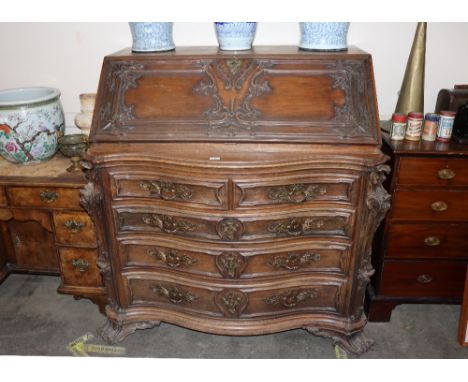 A large 19th Century continental carved rosewood bureau, the fall front opening to reveal an interior arrangement of drawers 