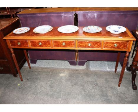 A walnut and cross banded hall table, fitted five drawers raised on turned reeded supports, 155cm wide x 37cm deep x 77cm hig