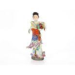 A Japanese porcelain model of a Geisha girl holding a basket of flowers, 33cm high