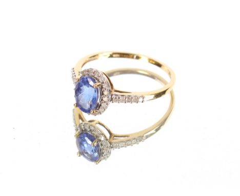 A 18ct gold tanzanite and diamond set ring, the oval tanzanite with brilliant cut diamond surround and diamond set shoulders,