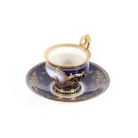A Vienna style porcelain chocolate cup and saucer, decorated with a panel of a battle scene on
