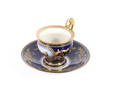 A Vienna style porcelain chocolate cup and saucer, decorated with a panel of a battle scene on rich blue ground heightened in