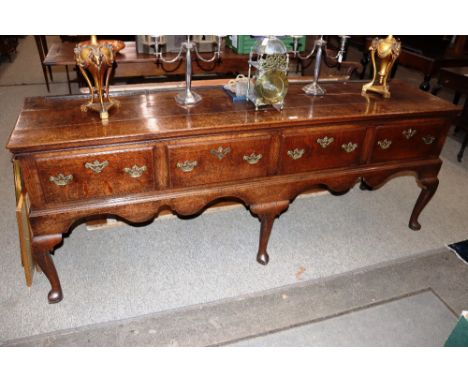 Early 18th Century oak dresser, having three plank top above four drawers with brass butterfly handles and escutcheons, raise