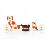A Victorian Staffordshire spaniel, 27cm high; a smaller similar 16cm high; a Jackfield type cow