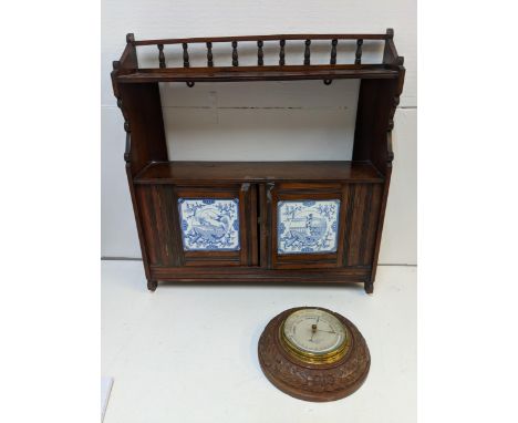 A late 19th century mahogany shelf with twin tiled doors, and a carved barometer Negretti & ZambraLocation: 