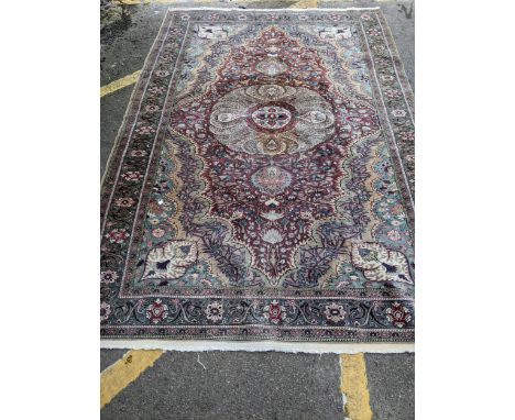 A Turkish hand woven woollen carpet, central floral medallion surrounded by all over floral designs, multi guard borders 291c